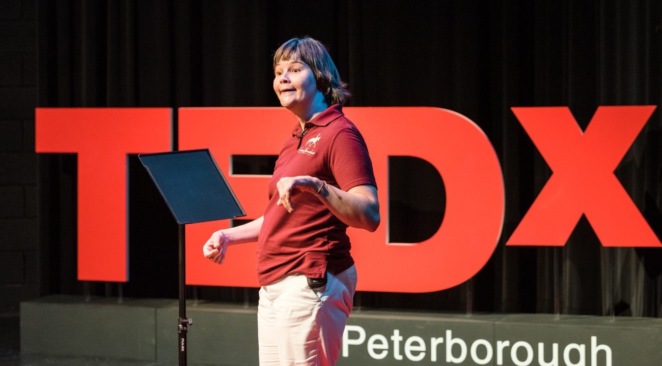 Emma Sheardown in front of sign saying TEDX Peterborough