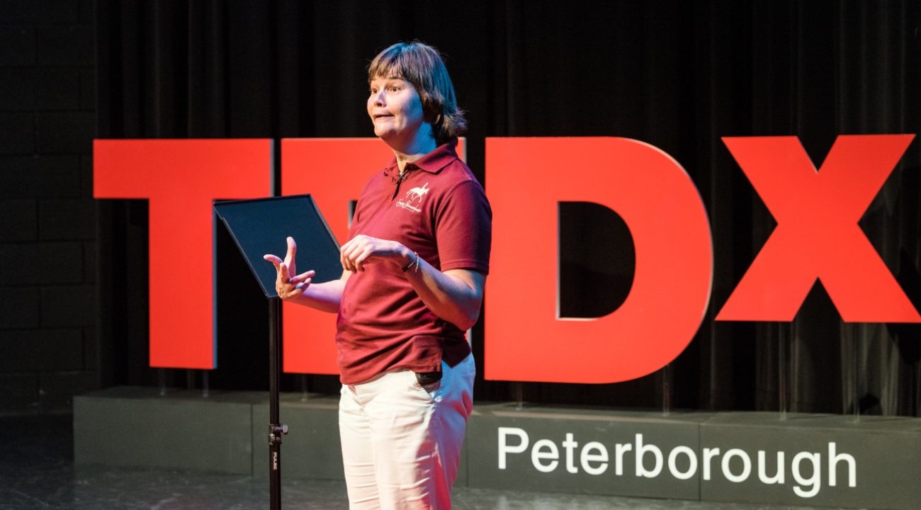 Emma Sheardown in front of sign saying TEDX Peterborough